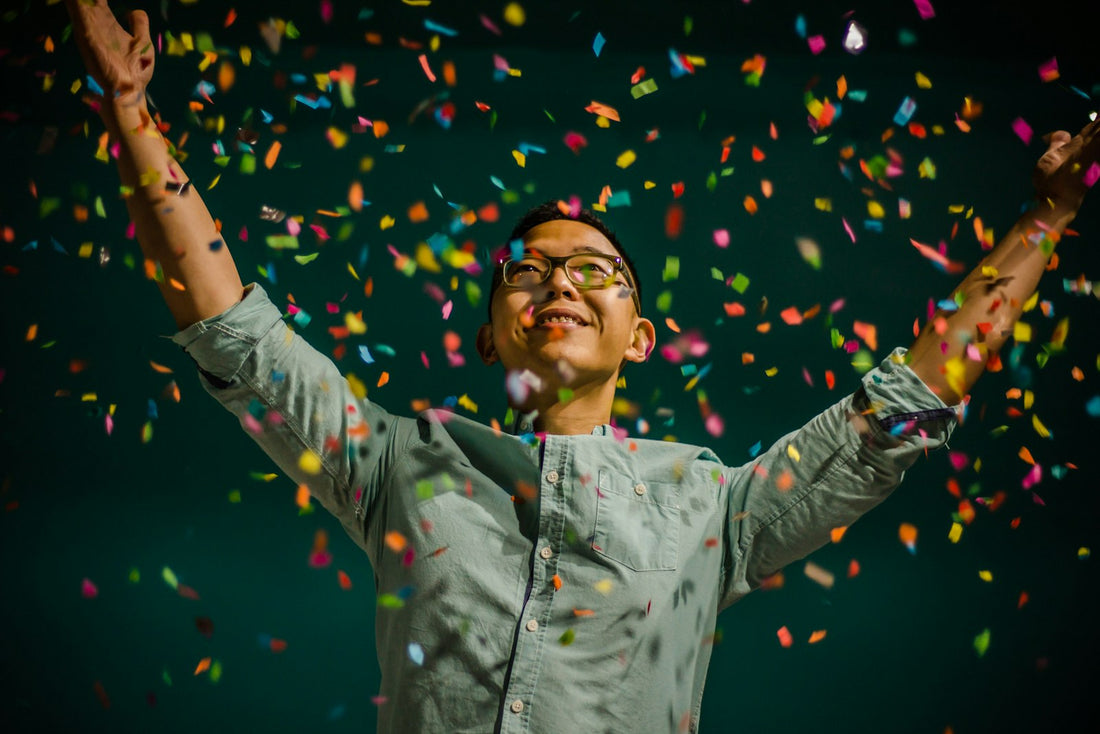 Man celebrating his retirement under falling confetti at a send-off party