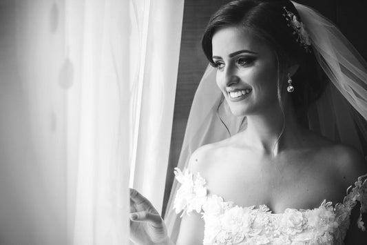 Smiling bride getting ready on her wedding morning before receiving a gift from the groom