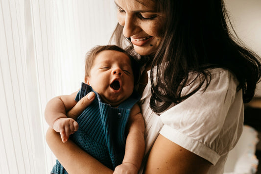 Smiling new mother holding her newborn baby, the inspiration for push present ideas