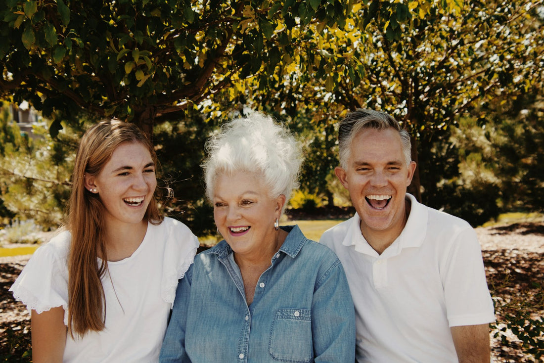 Three generations of a family smiling together outdoors for a 90th birthday