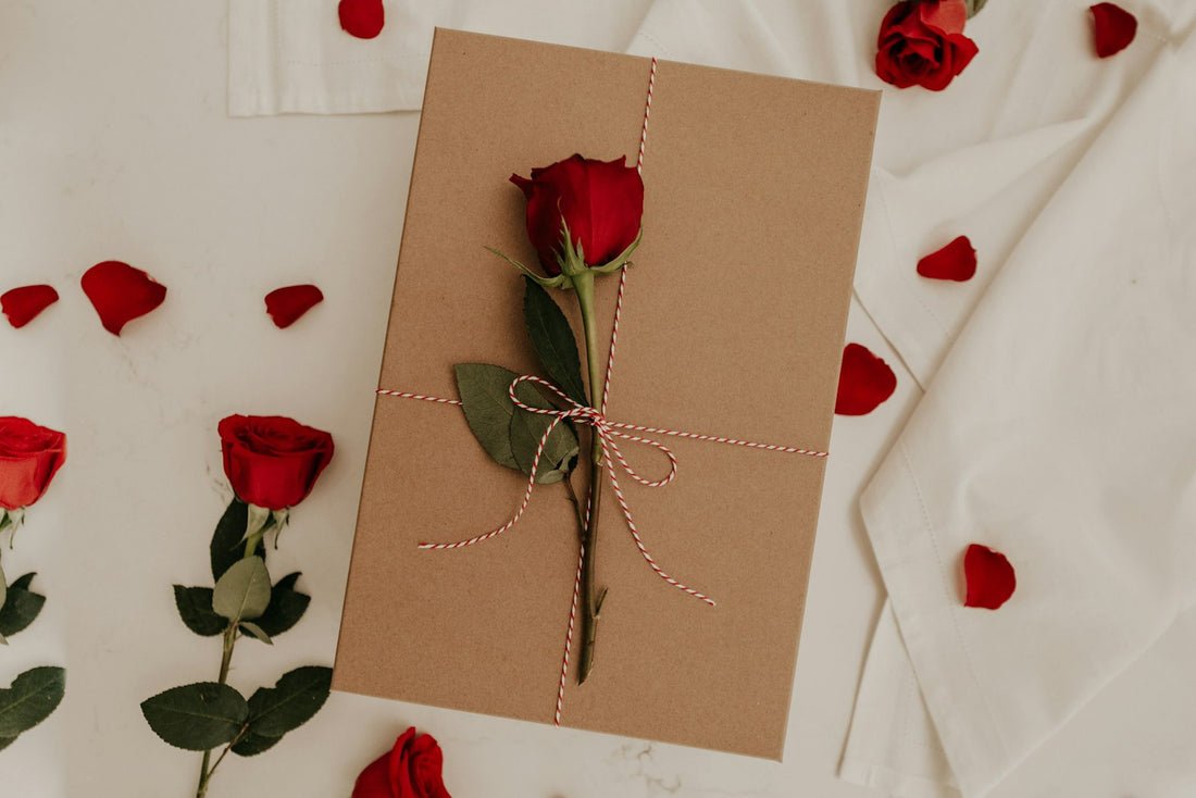 Anniversary card resting beside a single red rose