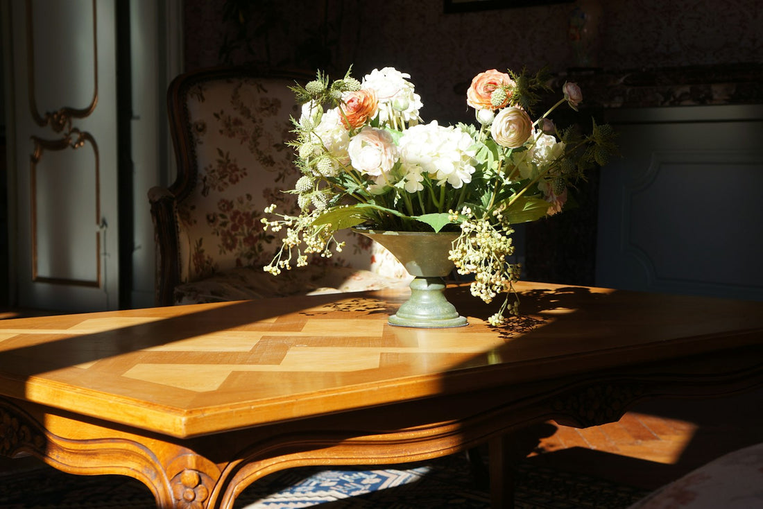 White flowers resting on a wooden table in soft, quiet light