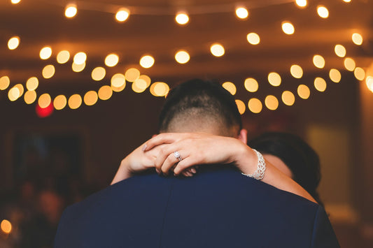 Wedding couple embracing under string lights during their first dance