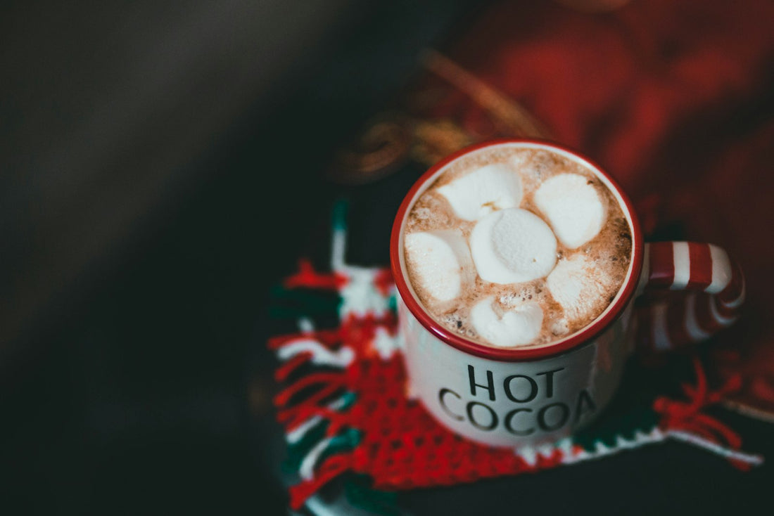 Mug of hot cocoa topped with marshmallows for a cozy Christmas Eve box