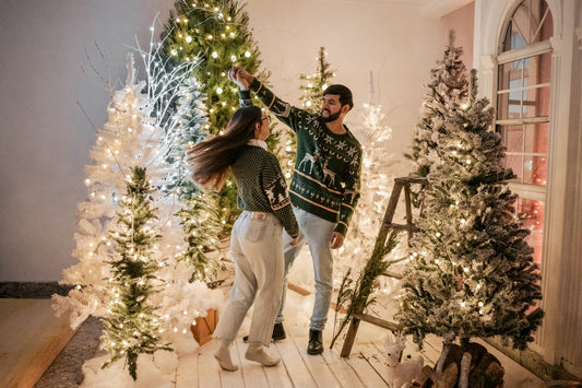 Couple slow dancing by the Christmas tree to romantic Christmas love songs
