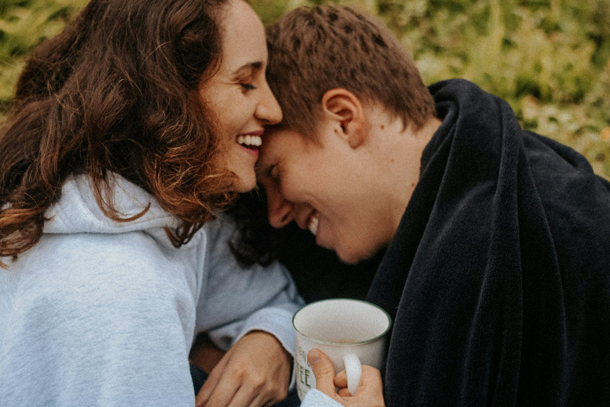 Young couple cuddling with warm drinks on a winter day before Christmas