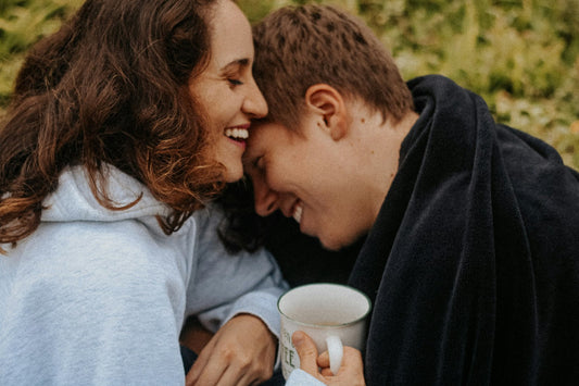 Young couple cuddling with warm drinks on a winter day before Christmas