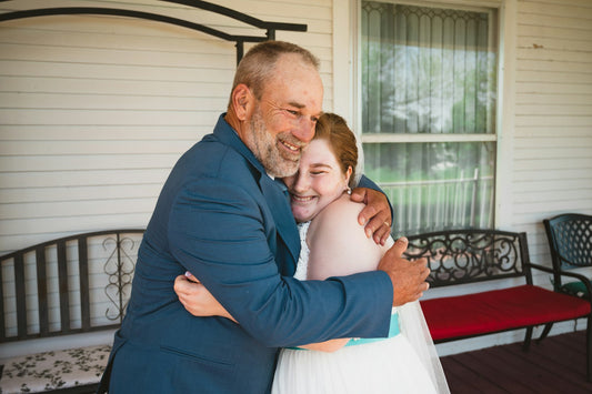 Adult daughter hugging her father on the porch on Father's Day