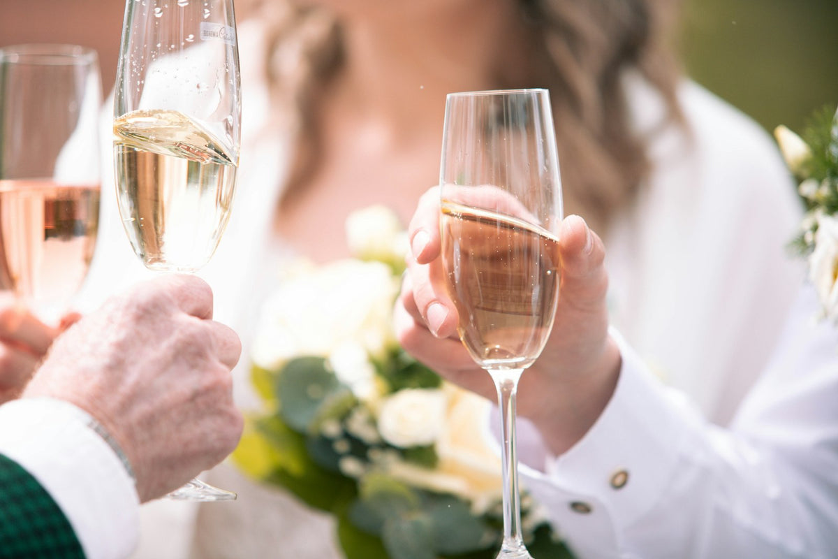 Happy newly engaged couple toasting with champagne glasses to celebrate