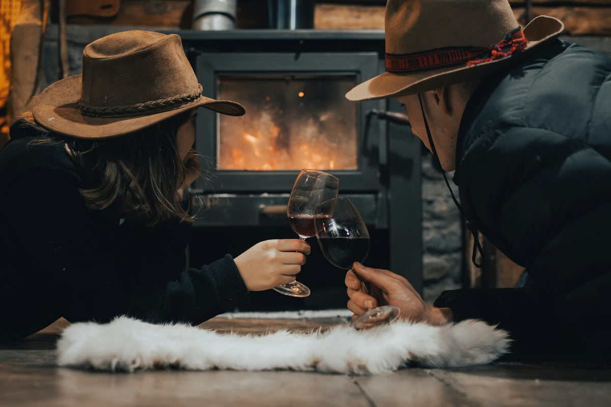 Newlywed couple wrapped in a blanket by the fireplace on their first married Christmas