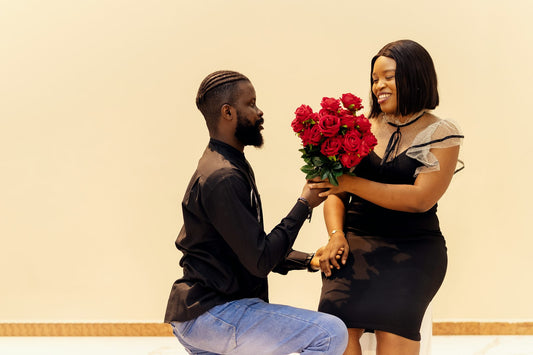Man surprising his smiling girlfriend with roses on Valentine's Day
