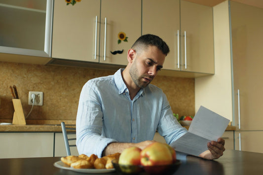 Husband smiling as he reads a handwritten Valentine's note in the kitchen