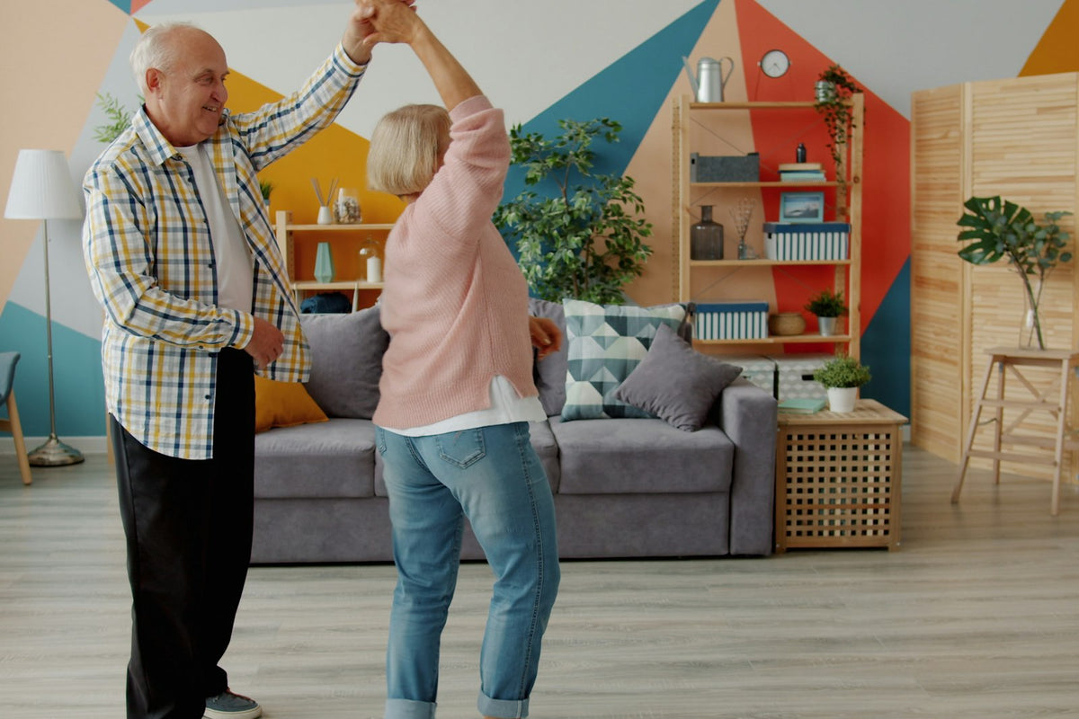 Older couple slow dancing in their living room to an anniversary song