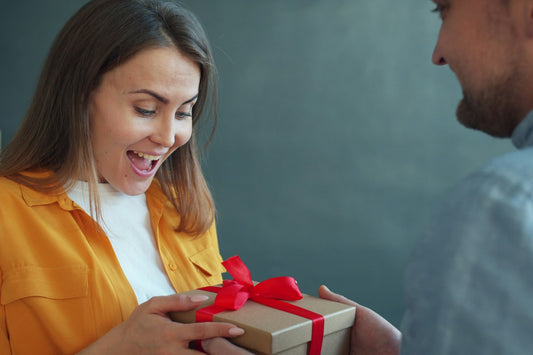 Woman looking delighted as she receives a surprise gift